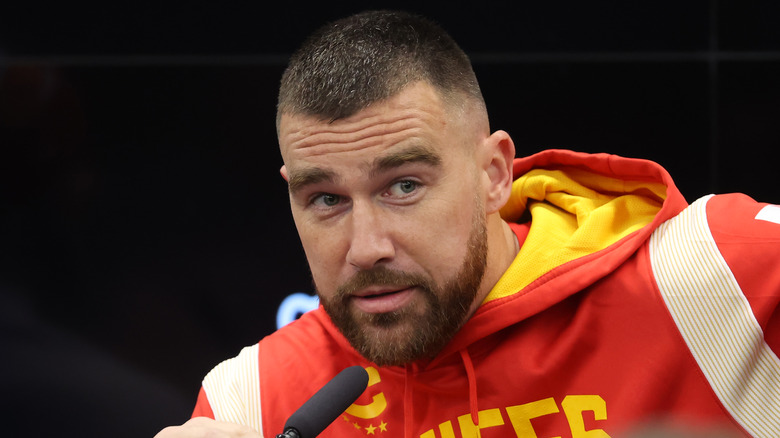 Travis Kelce speaking into a microphone