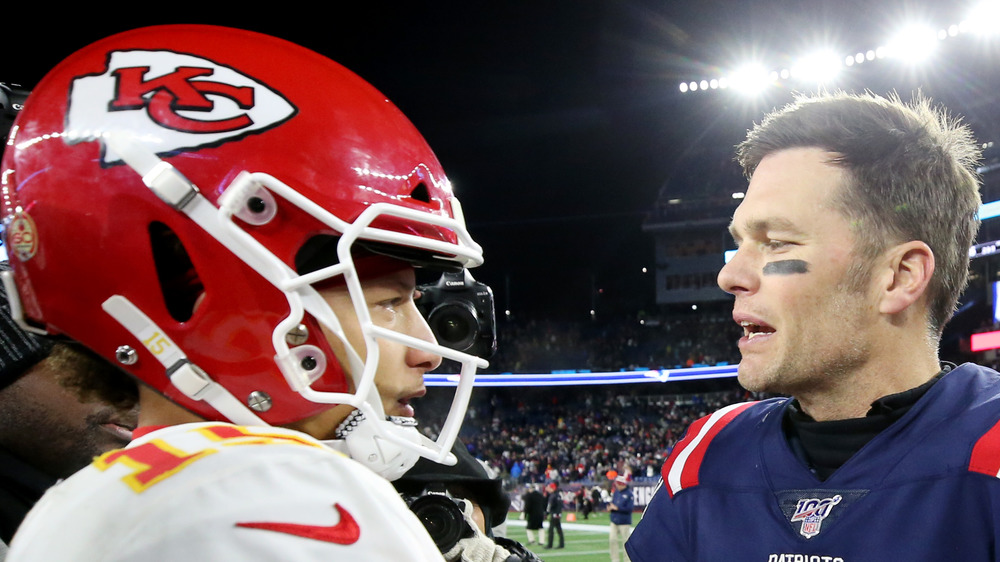 Tom Brady and Patrick Mahomes in helmet talking post Super Bowl