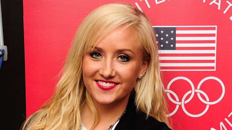 Nastia Liukin in front of US flag and olympic rings