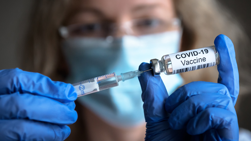 woman holding COVID-19 vaccine 