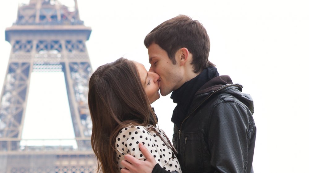 A couple kissing near the Eiffel Tower