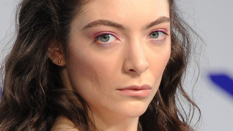 Lorde with serious expression on the red carpet