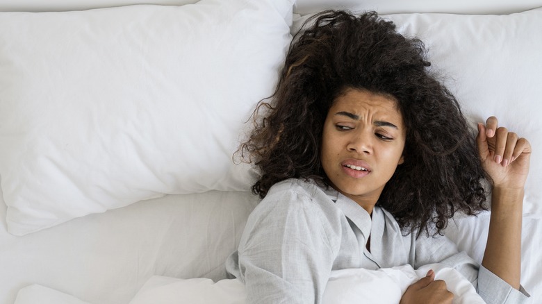 woman looking confused in bed