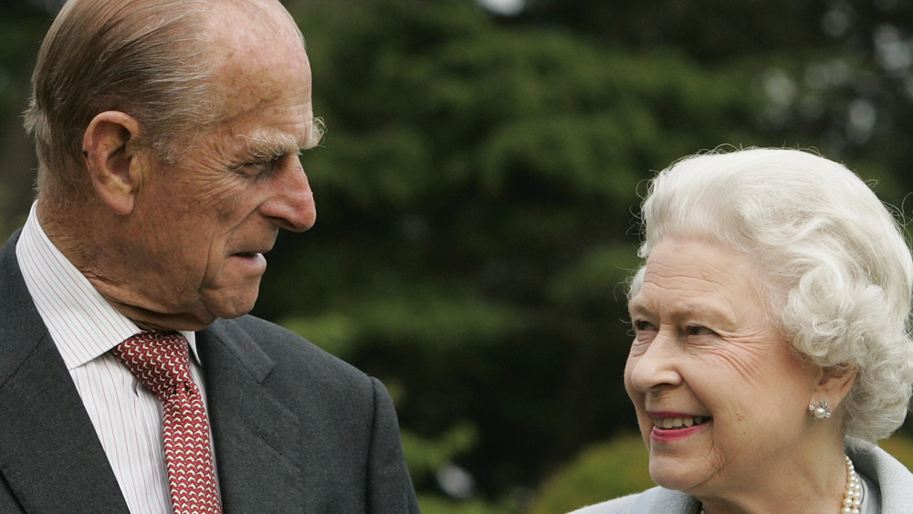 Queen Elizabeth and Prince Philip smiling at each other