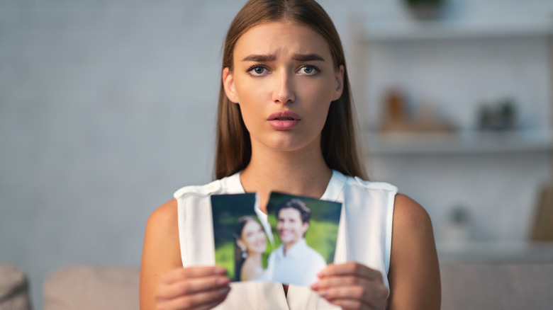 woman holding torn photo