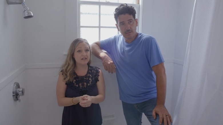 Kristina Crestin and Jonathan Knight looking concerned while standing in a shower on "Farmhouse Fixer"