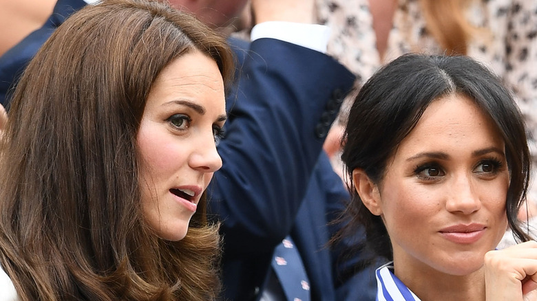 Kate Middleton and Meghan Markle conferring