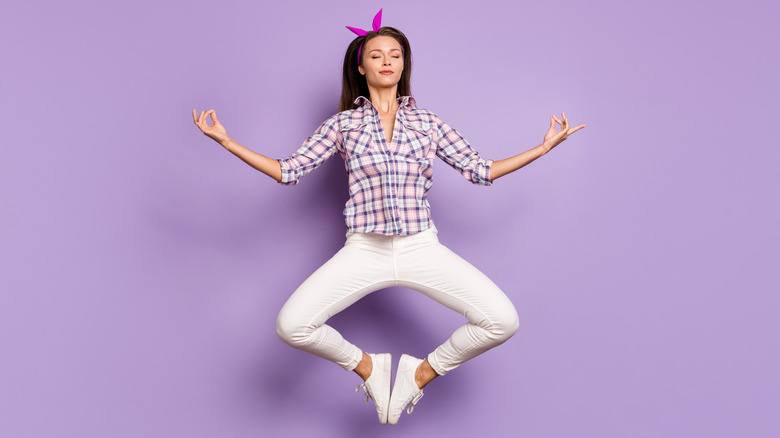 woman jumping against violet background