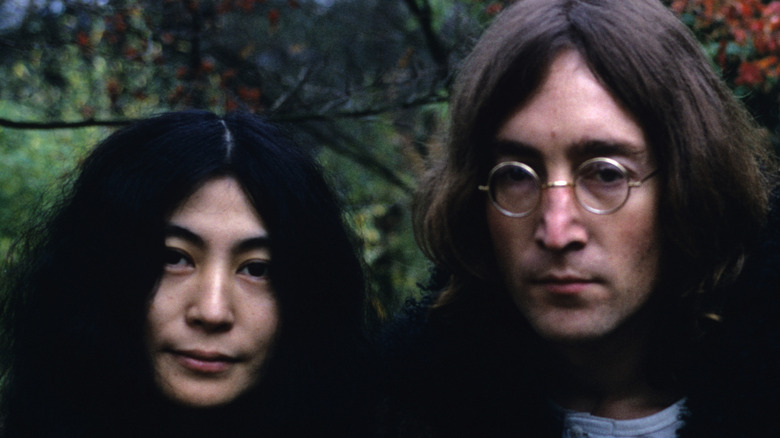 Yoko Ono and John Lennon standing in a forest