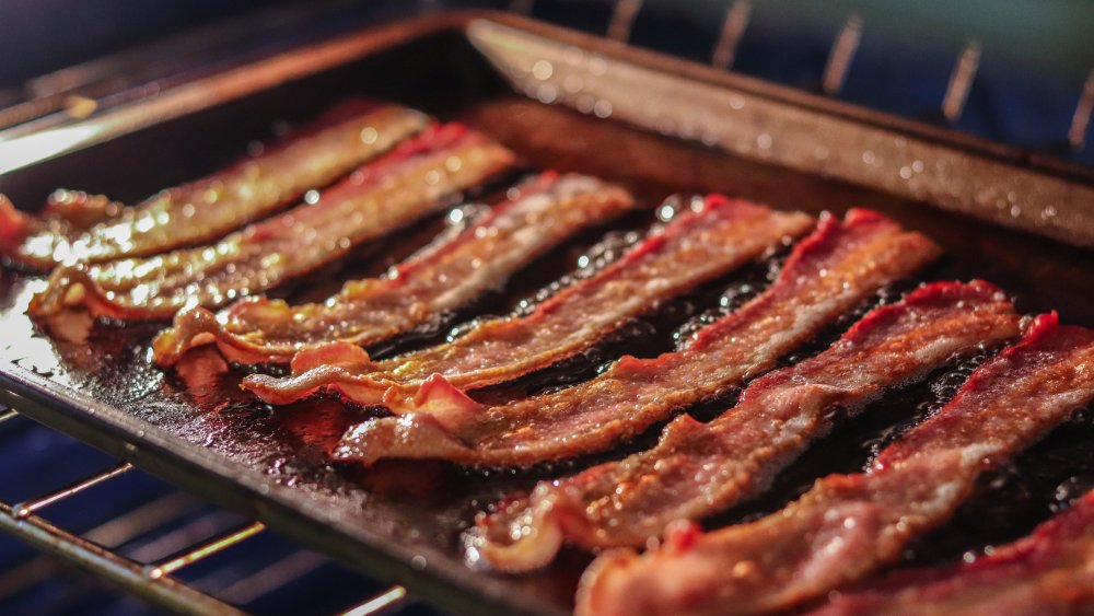 Bacon cooking on a baking sheet in the oven