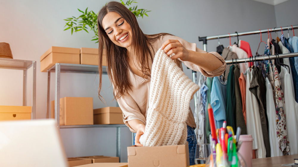 Woman packing clothes into brown box