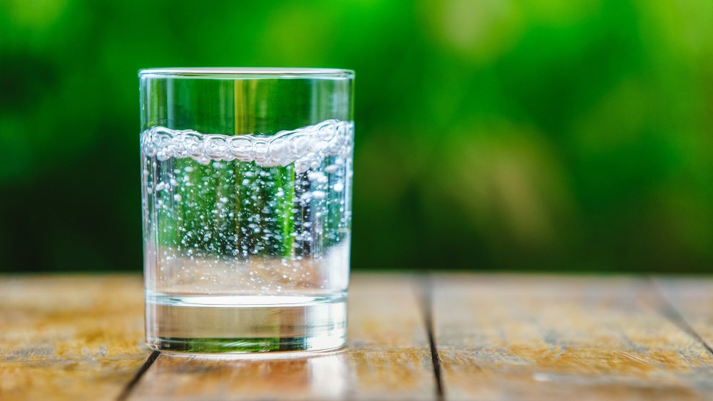 A glass of sparkling water on an outdoor table