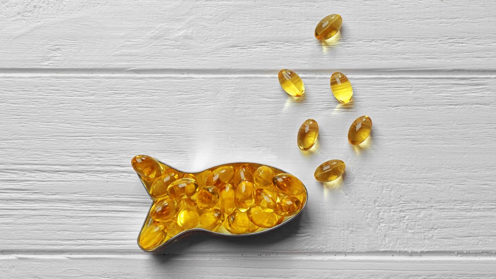 Fish oil supplements on a table in the shape of a fish