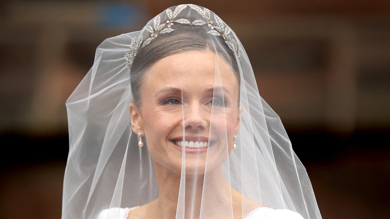 Olivia Henson smiles in her wedding veil 