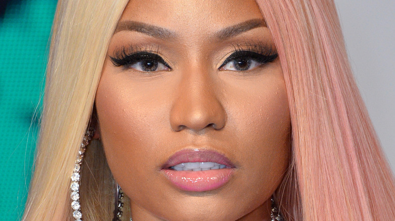 Nicki Minaj wears diamond earrings with straight blonde hair.
